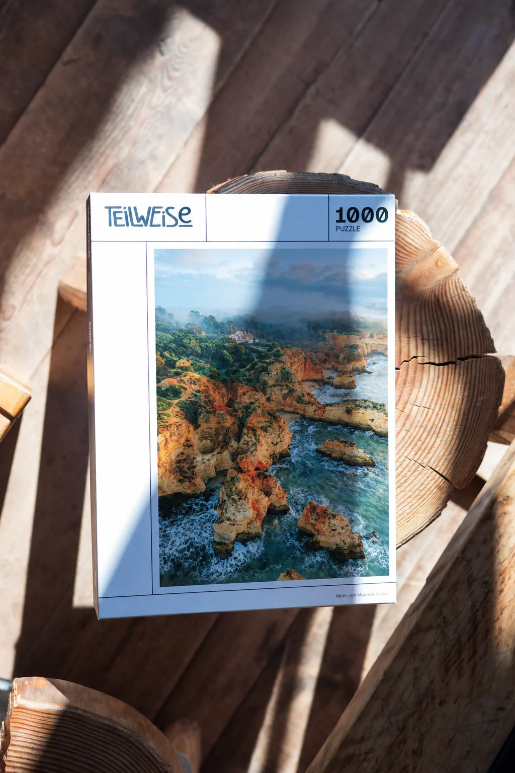 Puzzle mit Küstenlandschaft auf einem Holzschemel